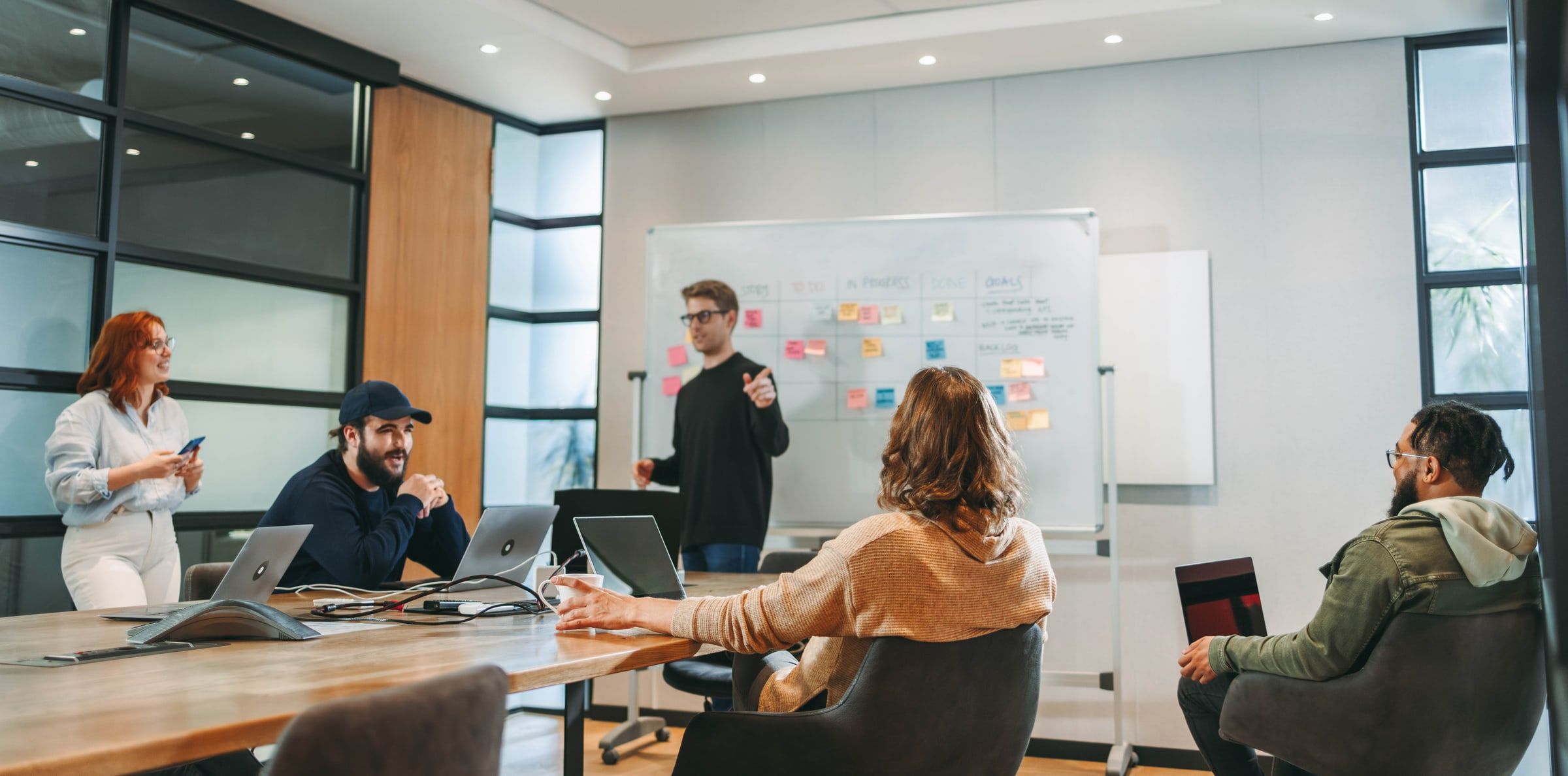 Product team planning around a whiteboard in a meeting room
