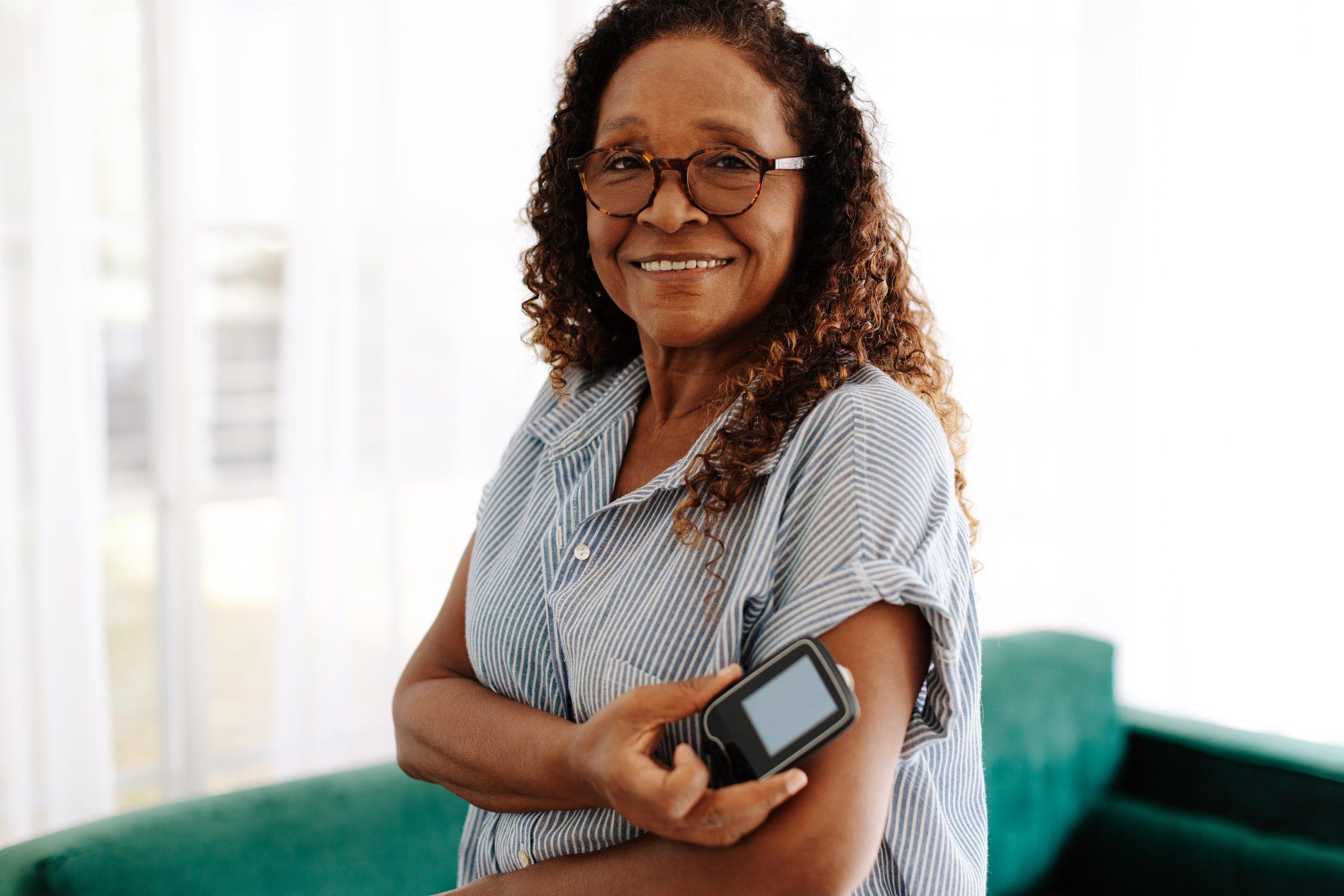 Woman scanning a continuous glucose monitor on her arm with a handheld reader